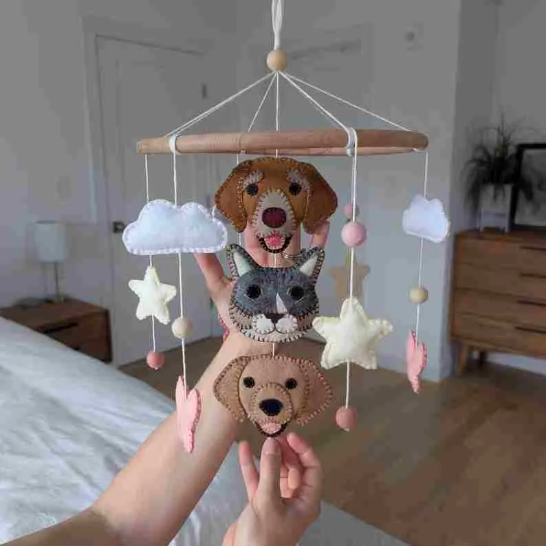Bring clouds and puppies into the nursery ✨ A handmade felt crib mobile, giving your baby their first gentle companionship.