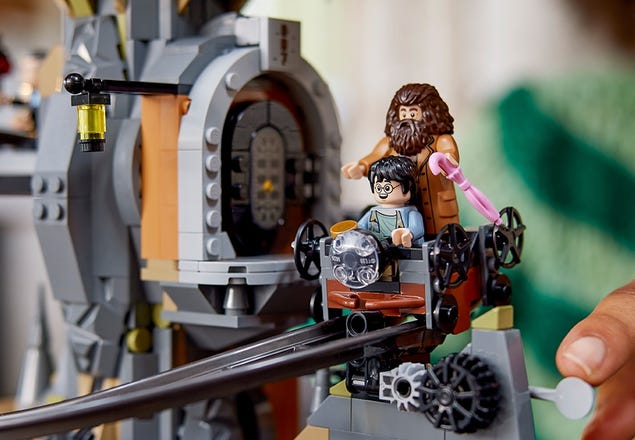 2 LEGO Harry Potter minifigure characters ride on a cart on a curved track