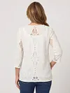 Back view of women's lace patchwork shirt showing intricate hollow-out embroidery and keyhole detail