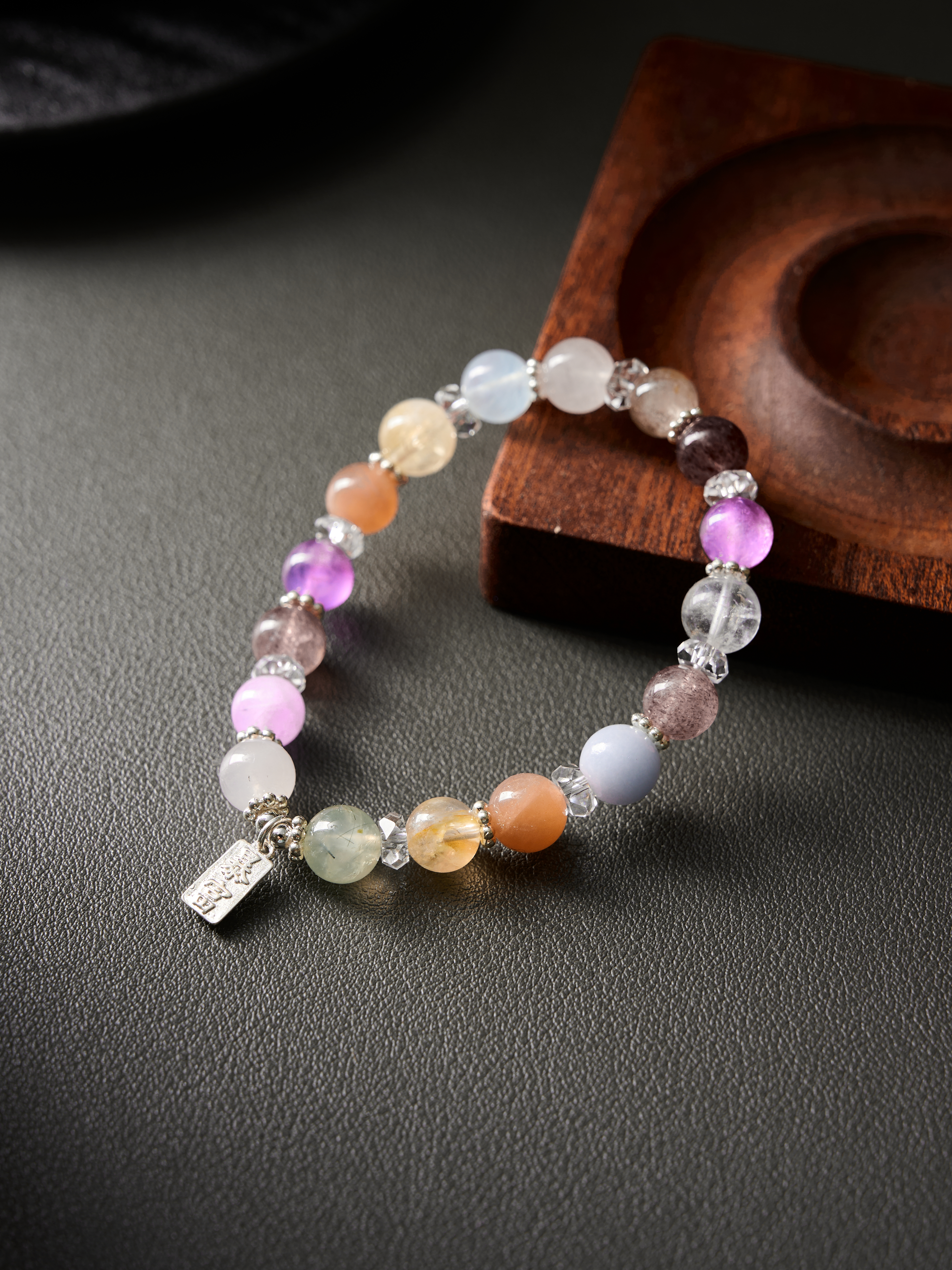 Side view showing bead profile and polish—aquamarine, amethyst and clear quartz on elastic cord
