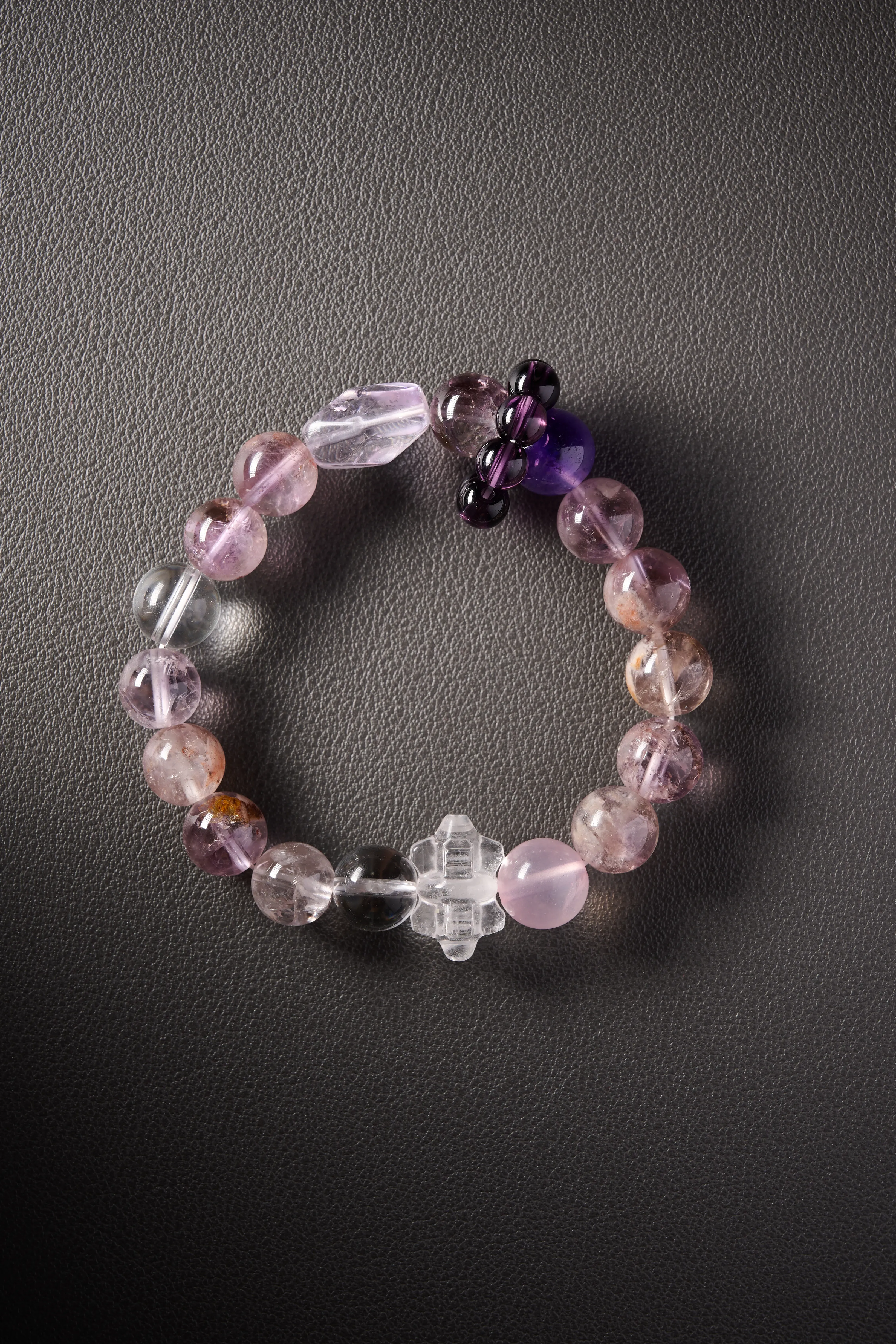 Hero image – amethyst, rose quartz and clear quartz beaded bracelet on dark background, polished round beads.