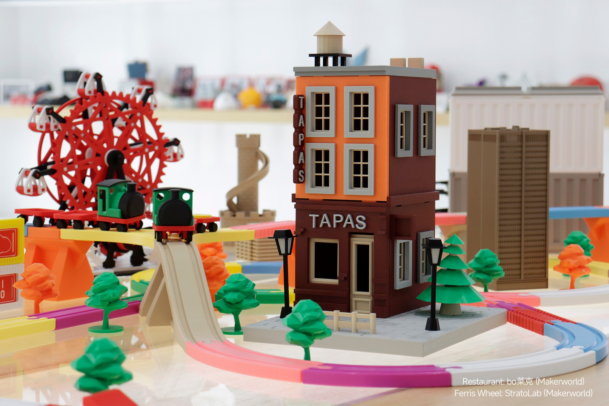 含'TAPAS'餐厅、摩天轮和火车的3D打印微缩城镇场景,儿童节想象游戏理想之选,体现3D打印在创造个性化游戏套装中的作用