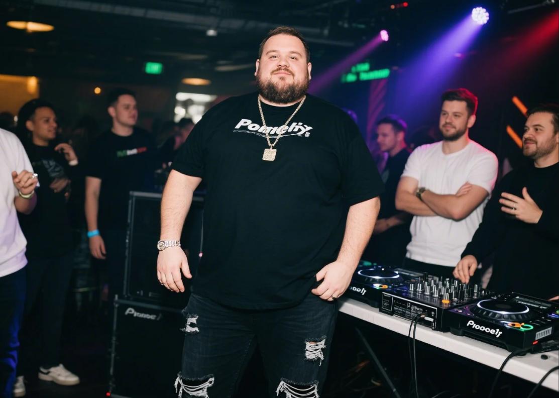 A big guy wearing black ripped jeans