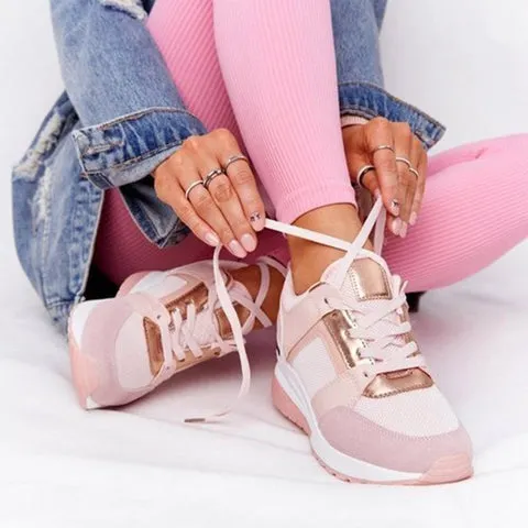 Rosa orthopädische schuhe, die von einer person im schneidersitz mit rosa leggings und einer jeansjacke geschnürt werden