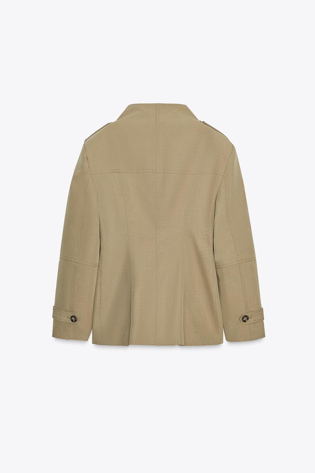 Back view of a light khaki jacket with a stand-up collar, long sleeves with tabs and epaulets, visible seams.