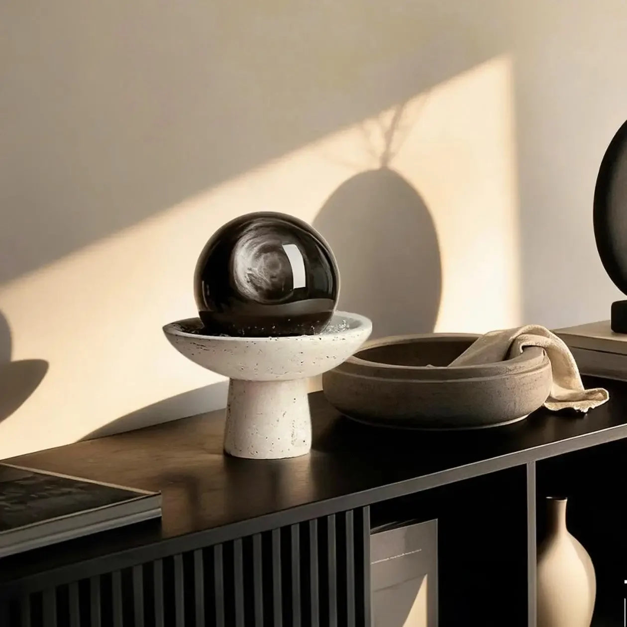Silver sheen obsidian sphere styled on a desk