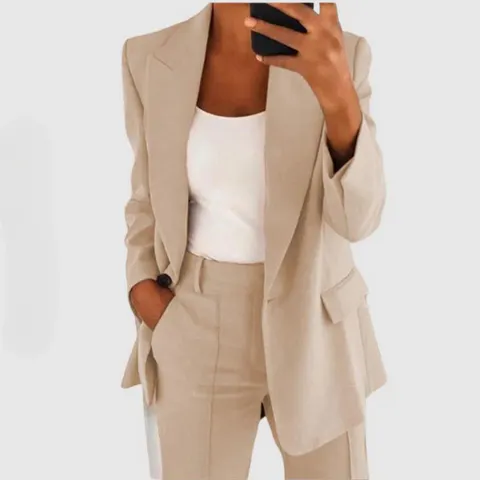 Spiegelbild einer Frau, die ein khakifarbenes Blazer-Set mit weißem Oberteil trägt