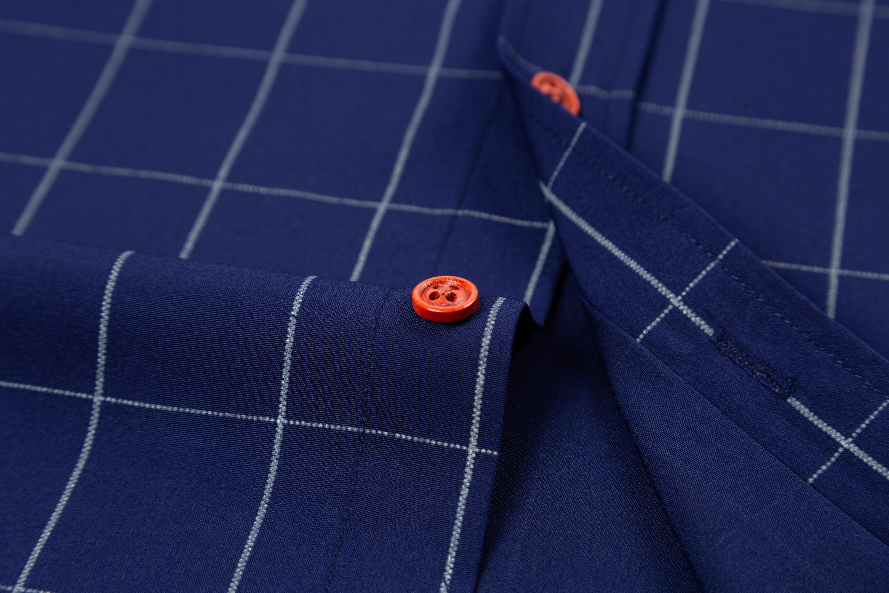 Two men’s long-sleeve shirts with a plaid color-block design, styled for business casual wear. Featuring a notched lapel collar that is sharp and well-structured, red buttons add a refined touch, and the blue-and-white plaid interior creates visual depth.