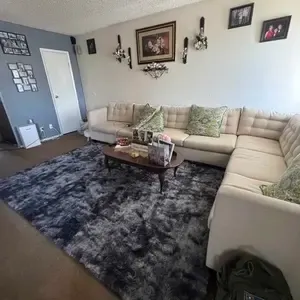 Customer photo: tie-dye dark grey rug under a sectional sofa