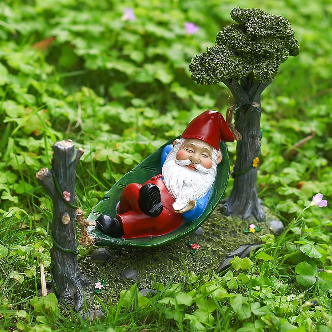 Garden Gnome Statue Lying In Hammock Hanging From Tree