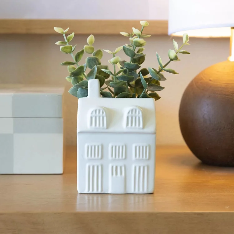 The porcelain house hides greenery, and the eucalyptus trees reflect the tabletop