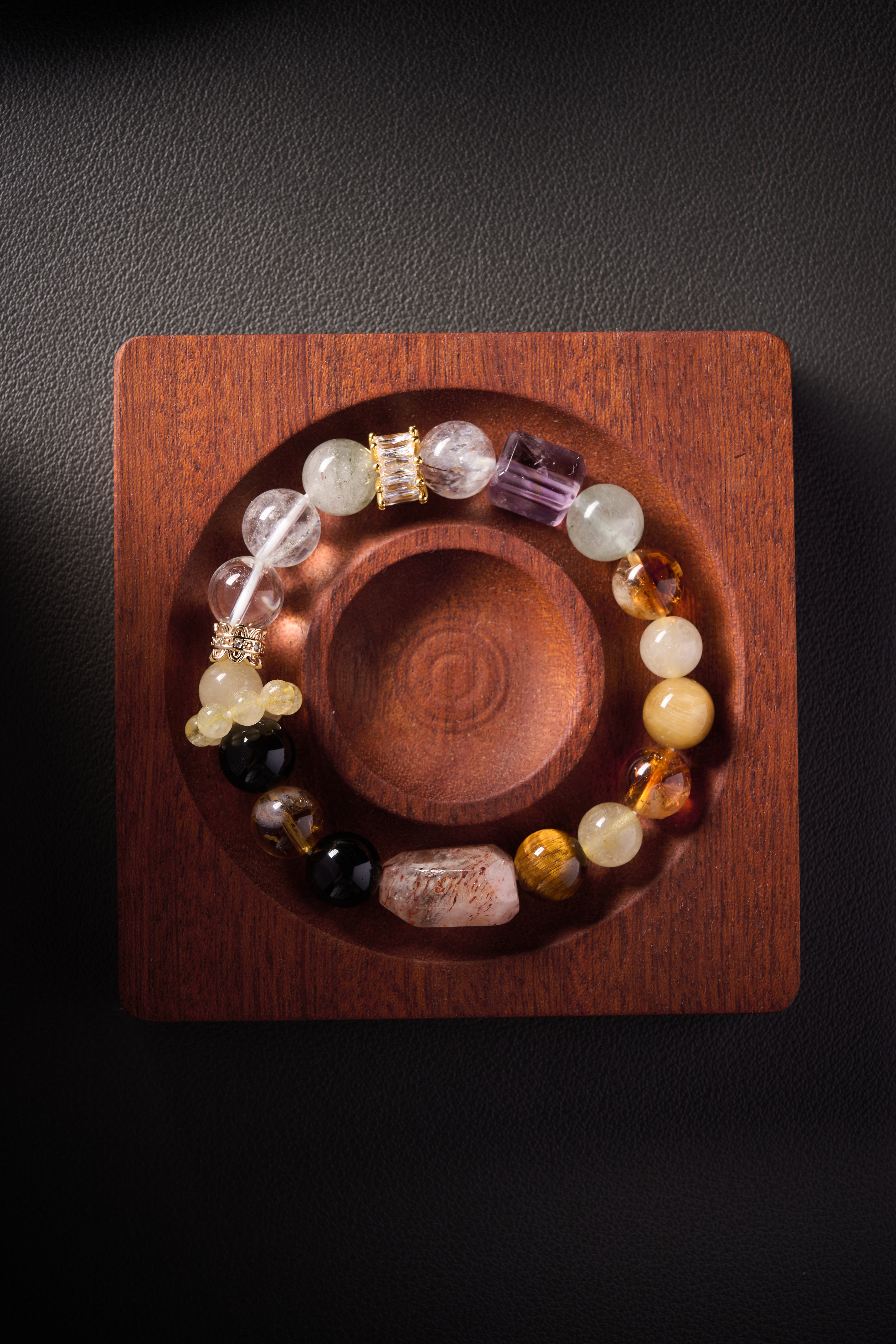 Detail focus – tiger’s eye chatoyancy stripes with reflective sheen beside obsidian beads.