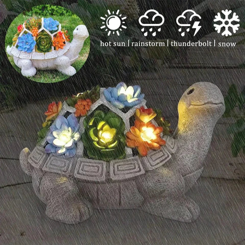 A decorative gray turtle statue with a segmented shell holds colorful artificial succulents.