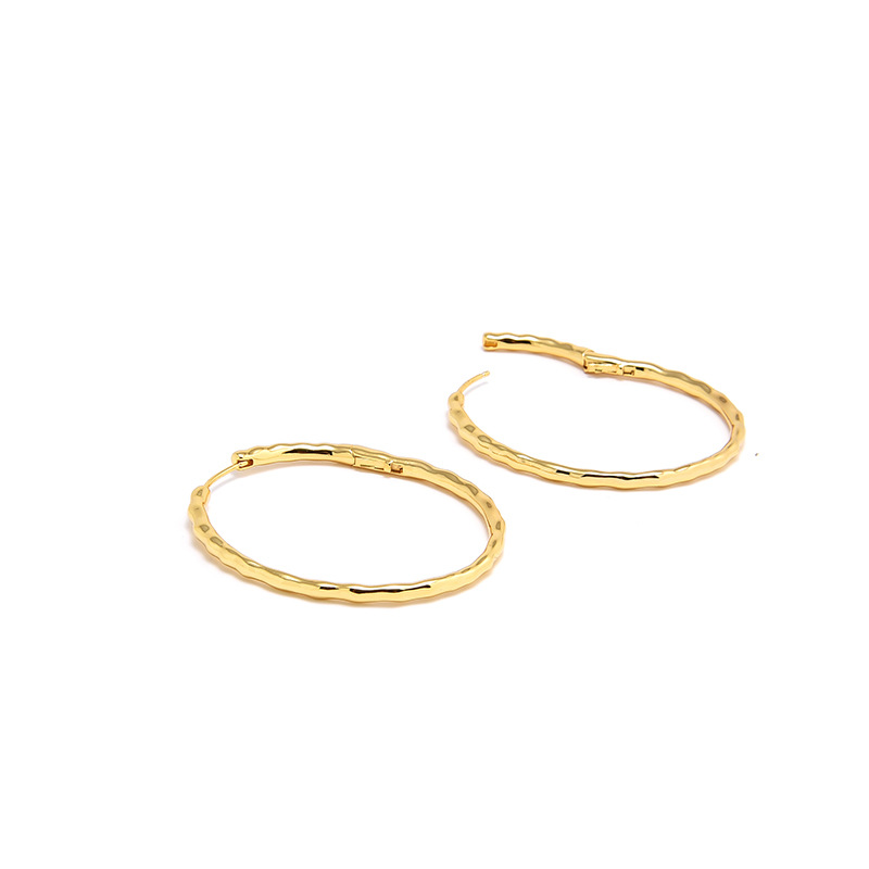 Detailed view of the textured finish on Muse oval hoop earrings