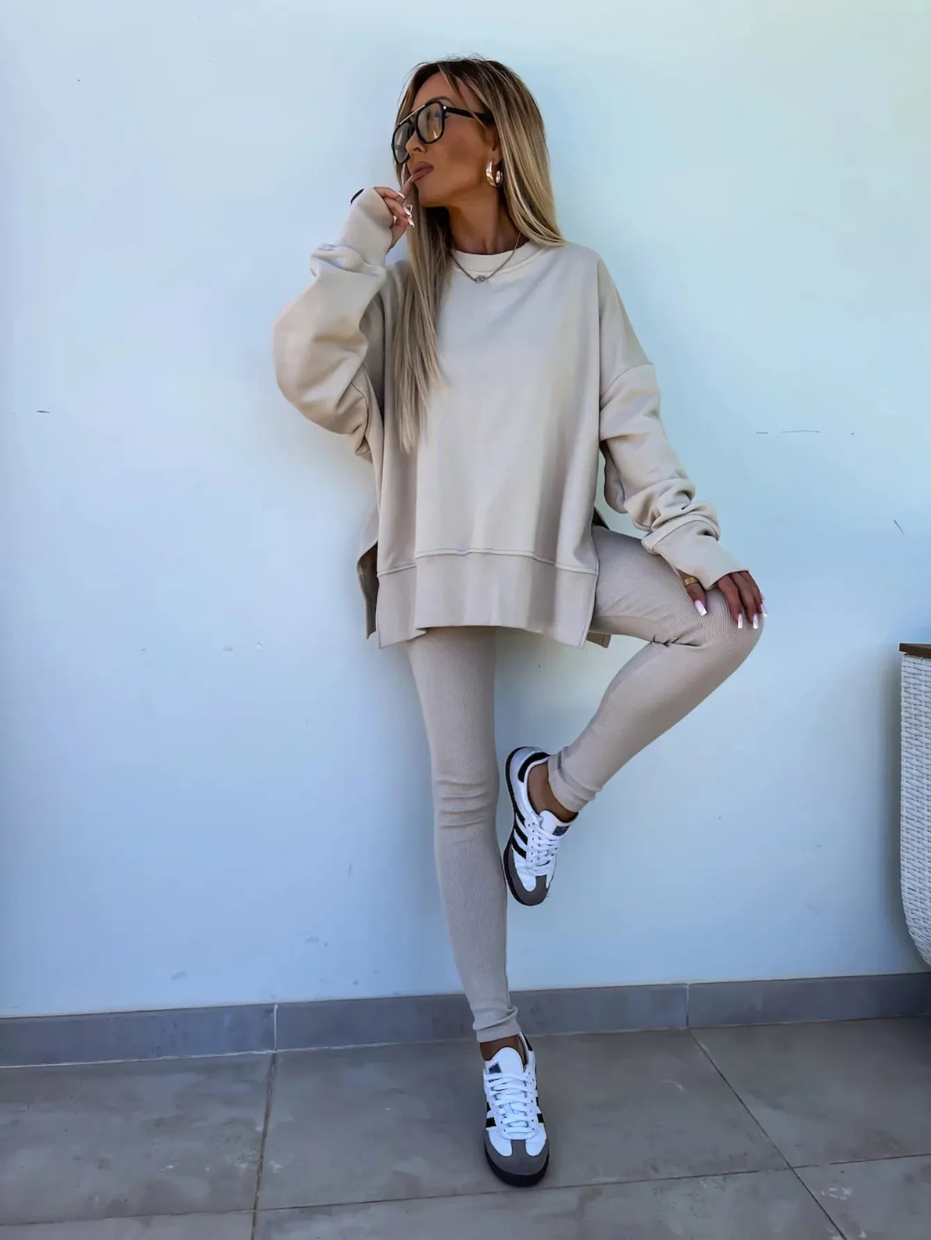 A leisure suit consisting of a round-neck, long, loose sweatshirt and high-elasticity slim-fit trousers. The model is wearing it for display.