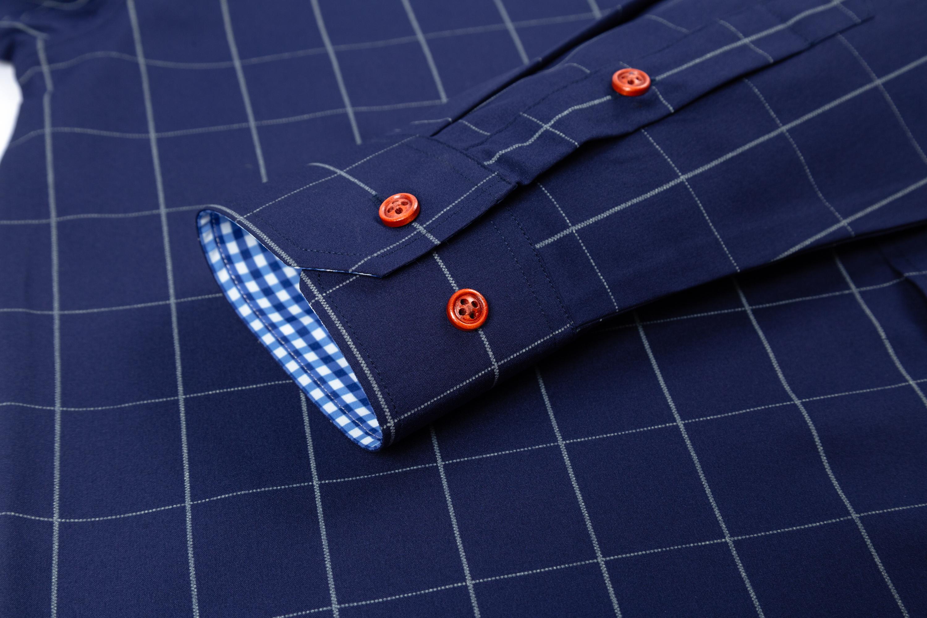 Two men’s long-sleeve shirts with a plaid color-block design, styled for business casual wear. Featuring a notched lapel collar that is sharp and well-structured, red buttons add a refined touch, and the blue-and-white plaid interior creates visual depth.