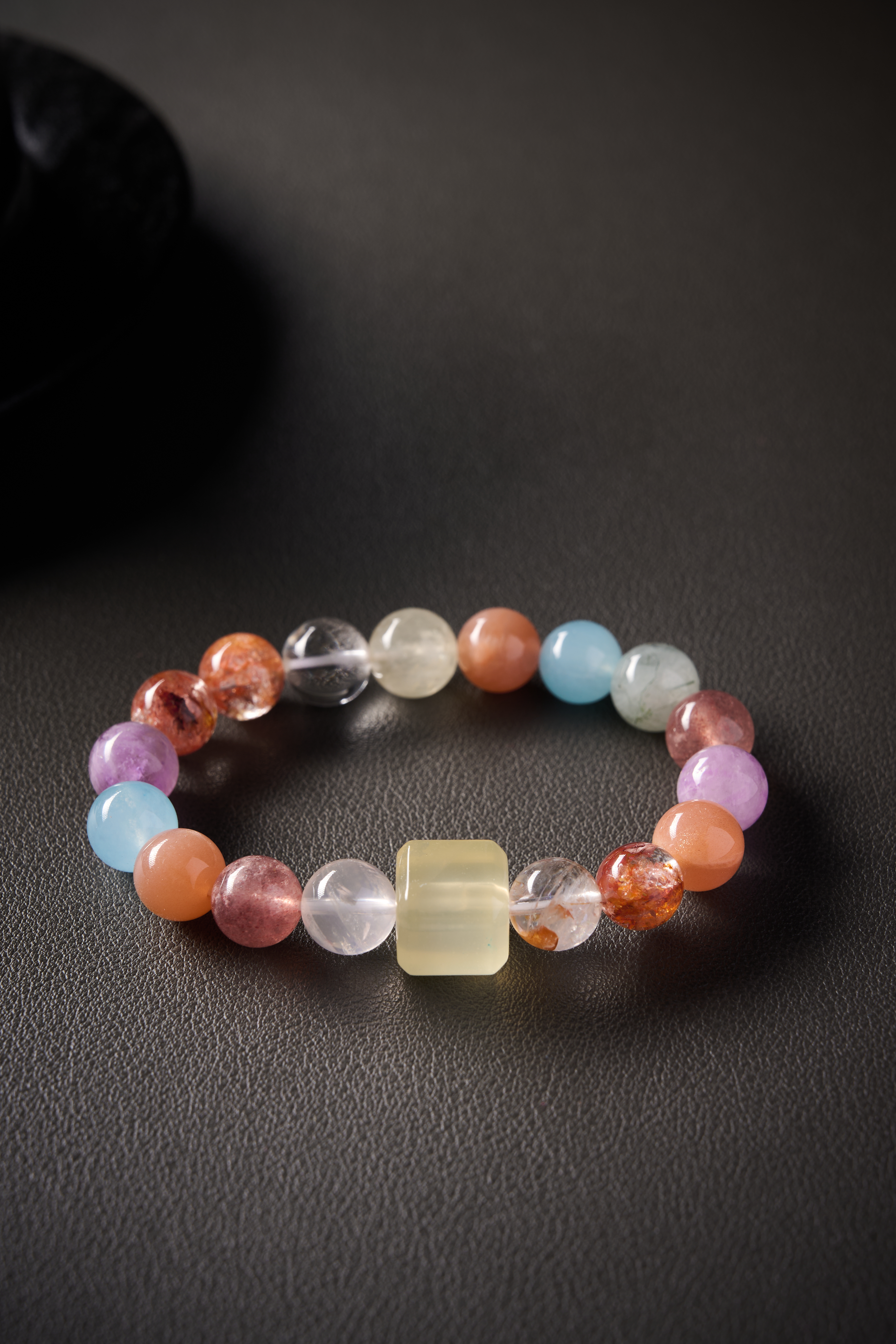 Close-up – sunstone beads showing warm orange glow and subtle sparkle, polished round surface.