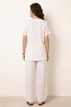 Back view of women's white linen resort suit showing relaxed fit top and high-waisted pants