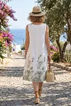 Back view of white sleeveless linen blend shift dress with green floral print