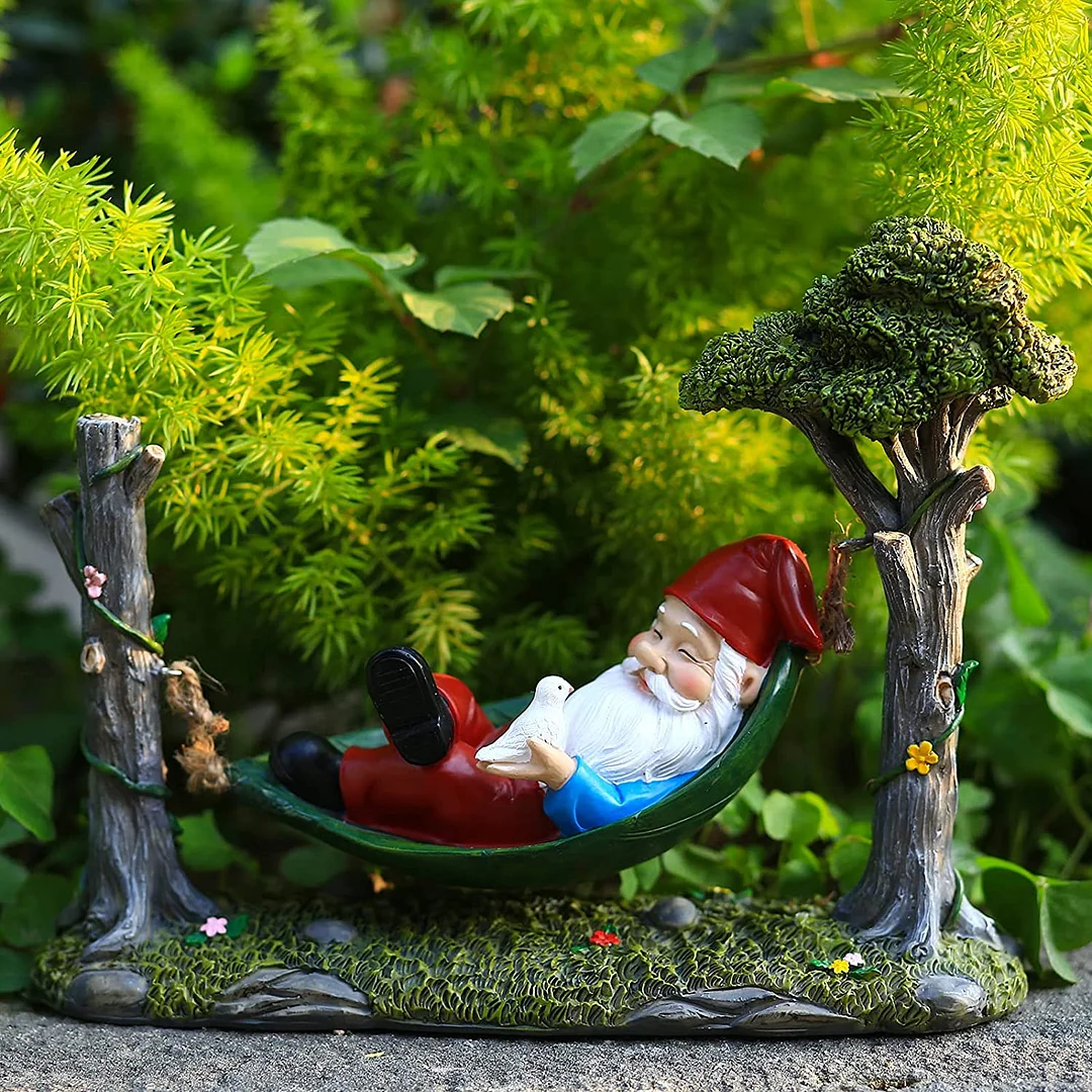 Garden Gnome Statue Lying In Hammock Hanging From Tree