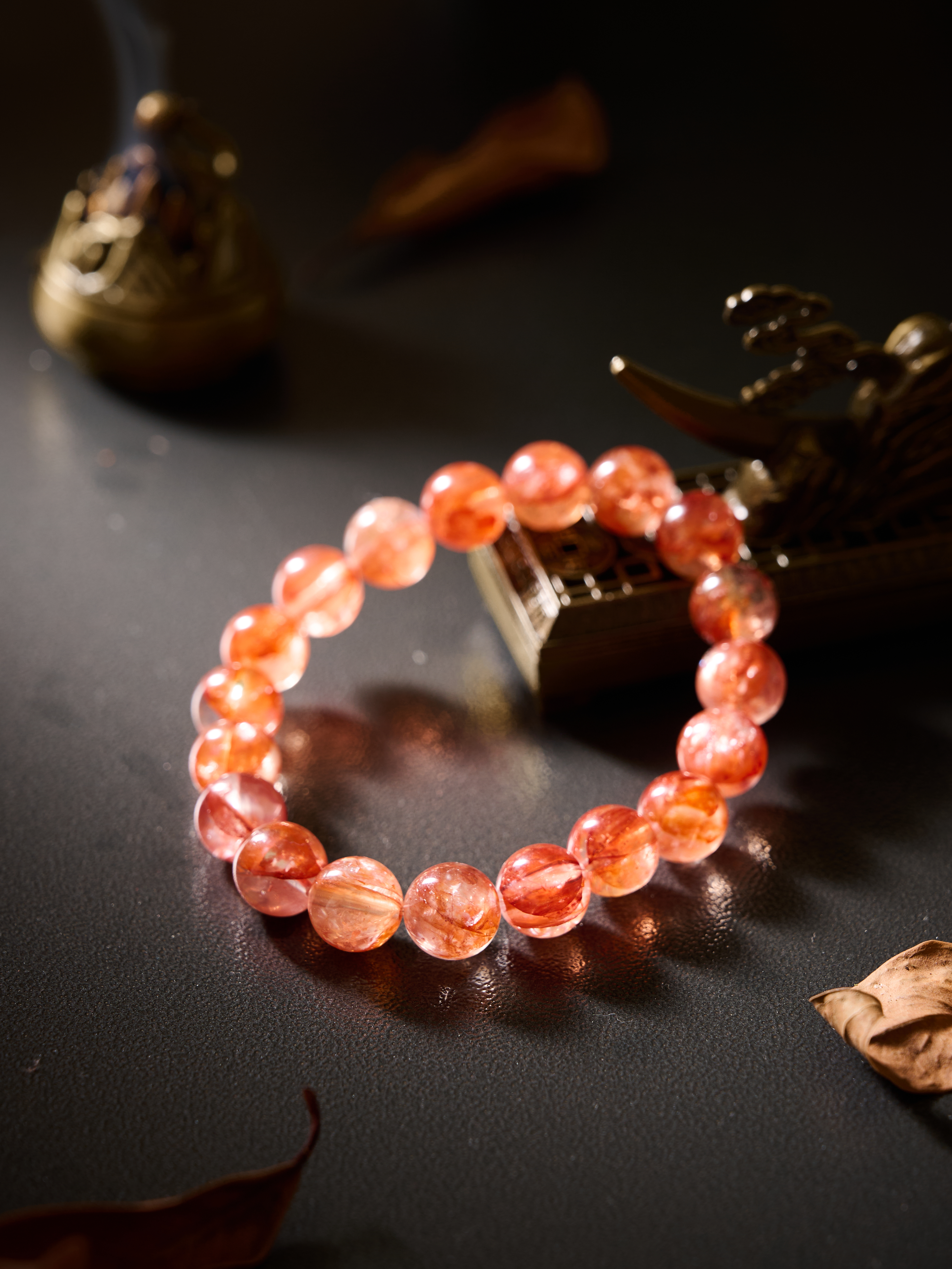 Diagonal flat composition highlighting red garden quartz translucency and sparkle, hand-strung bracelet