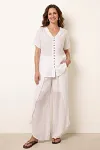 Front view of white pure linen two-piece set featuring V-neck button-up top and slit wide-leg pants