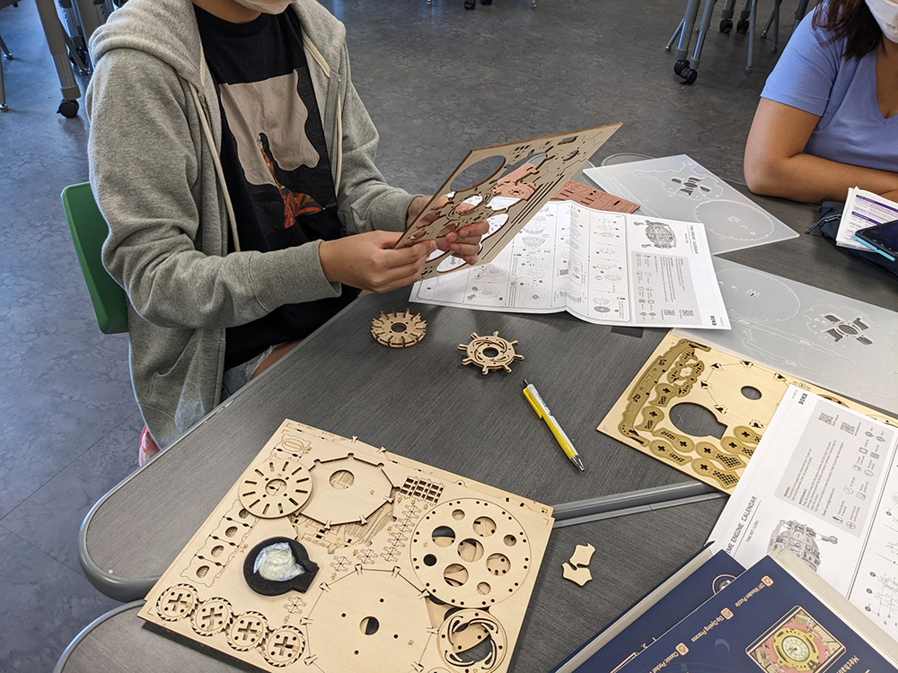 The students are working hard to study the instructions and the wooden boards in their hands