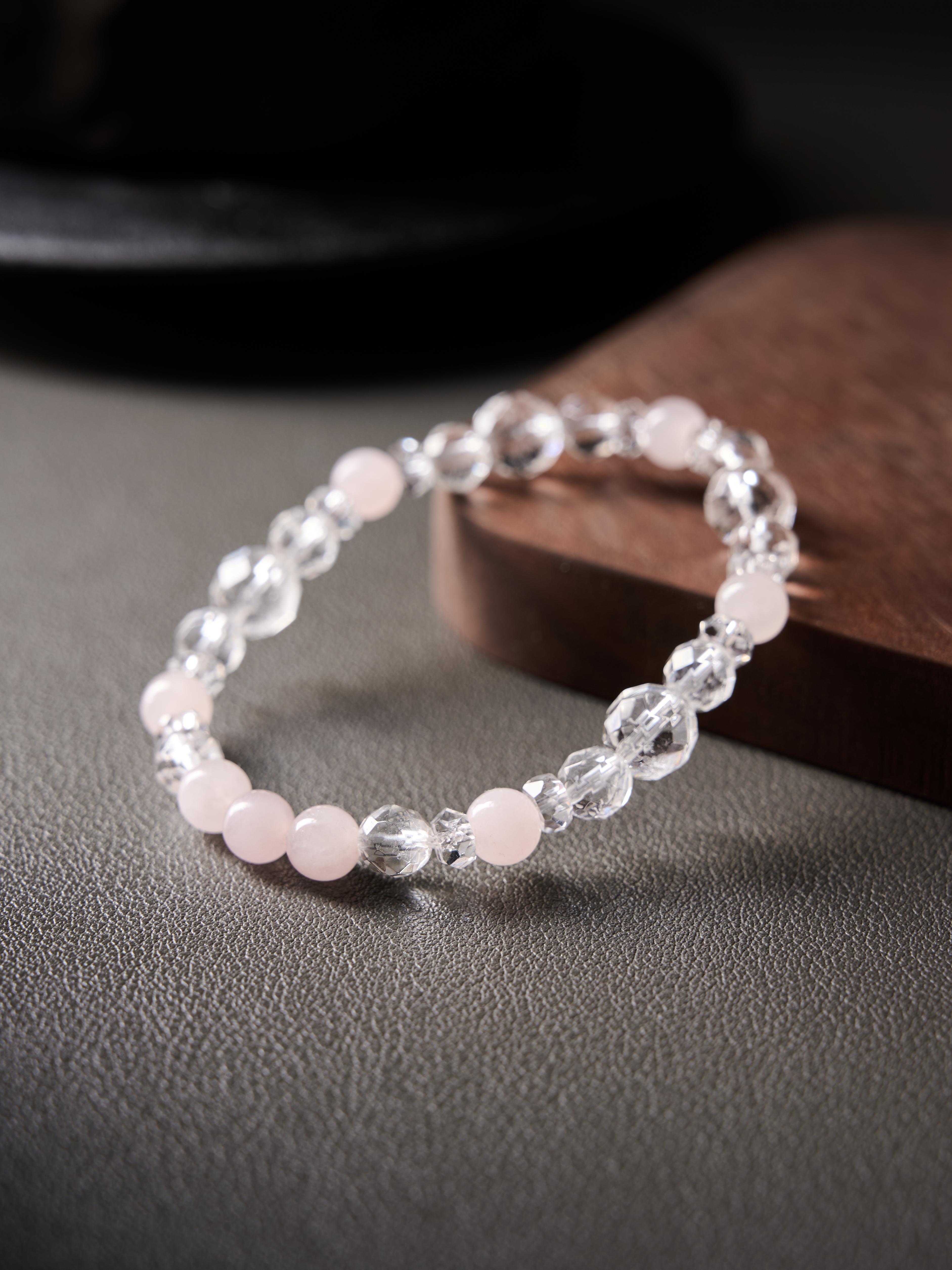 Macro side angle focusing on faceted clear quartz and smooth rose quartz rounds