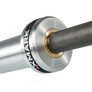 A zoomed-in view of the end of an XMark weight bar showing chrome sleeve, logo band, & brass bushing