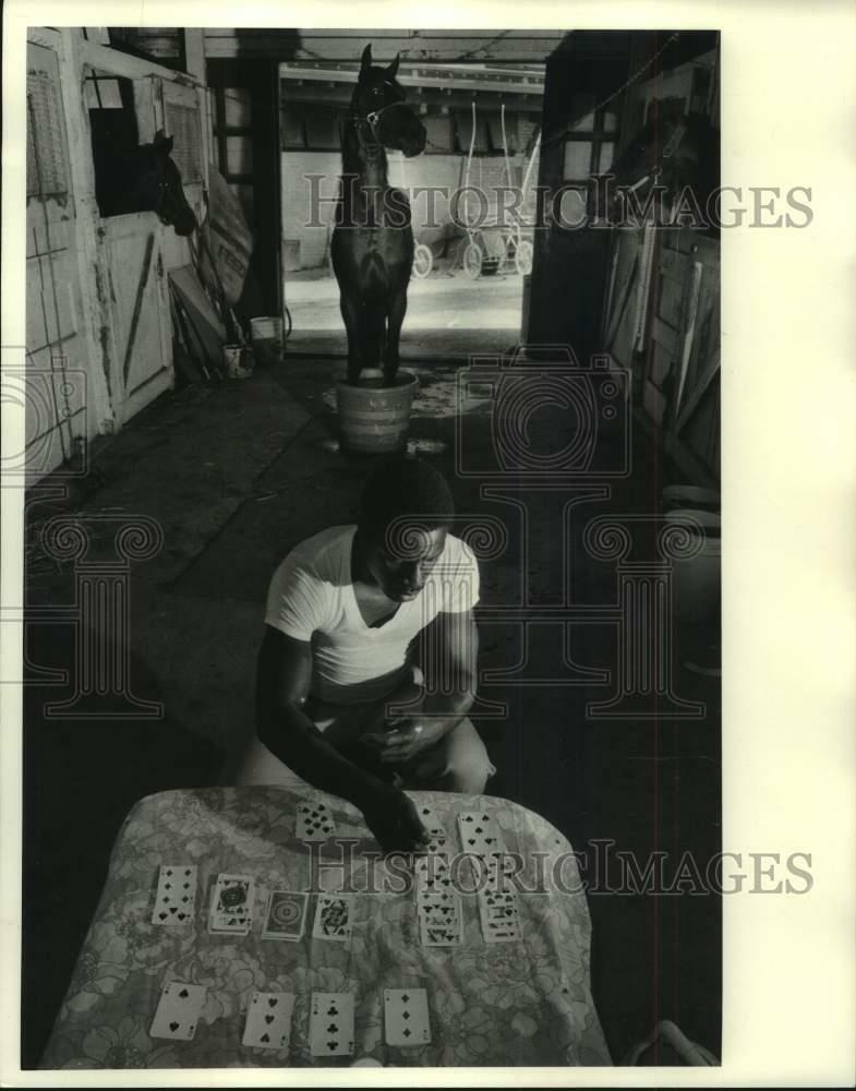 Press Photo Poster painting Stable Hand plays Solitaire while Race Horse soaks Hooves in Water