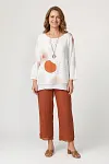 Front view of women's white linen tunic with abstract geometric print and terracotta wide-leg pants
