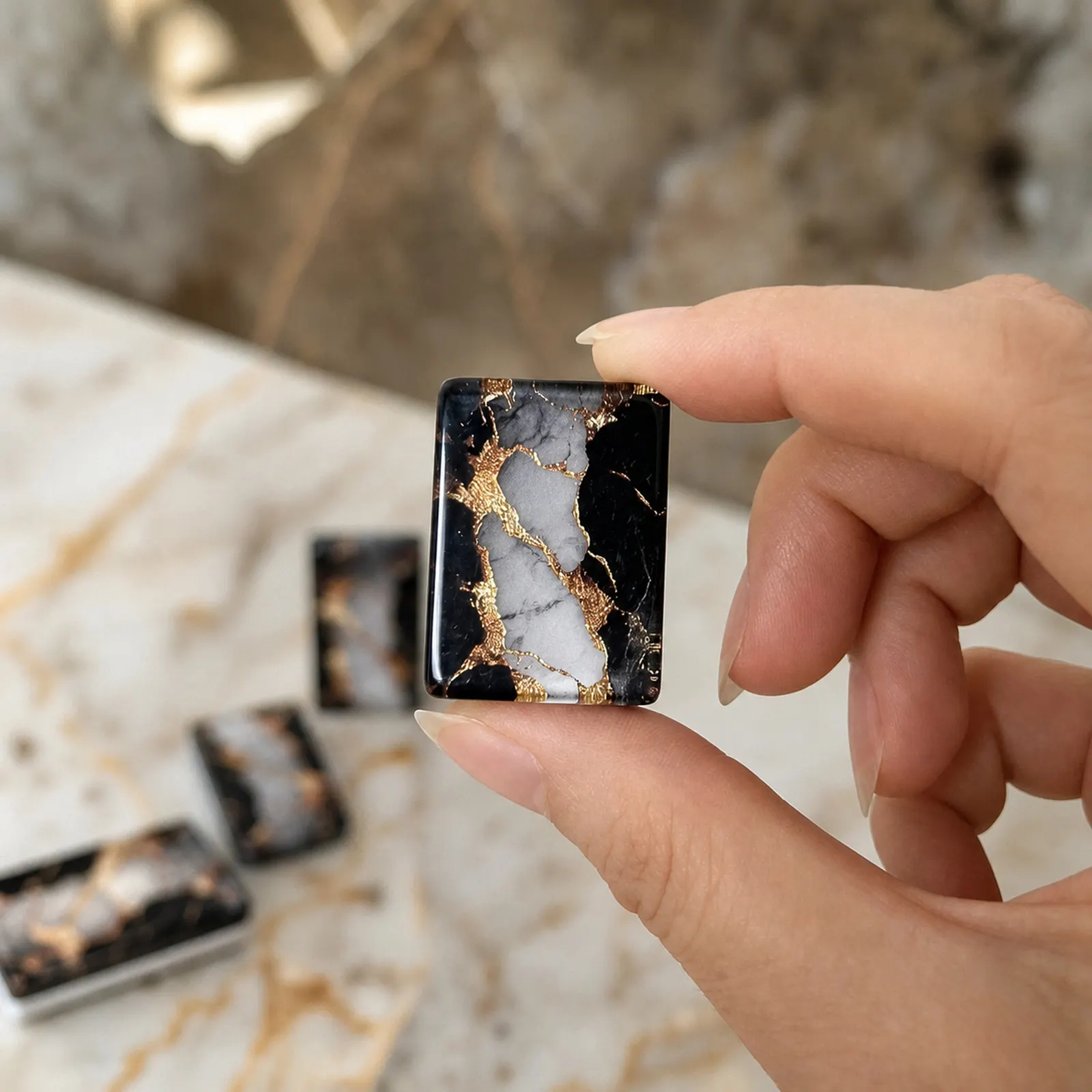 Close detail of midnight-black backs with gold marble veining.