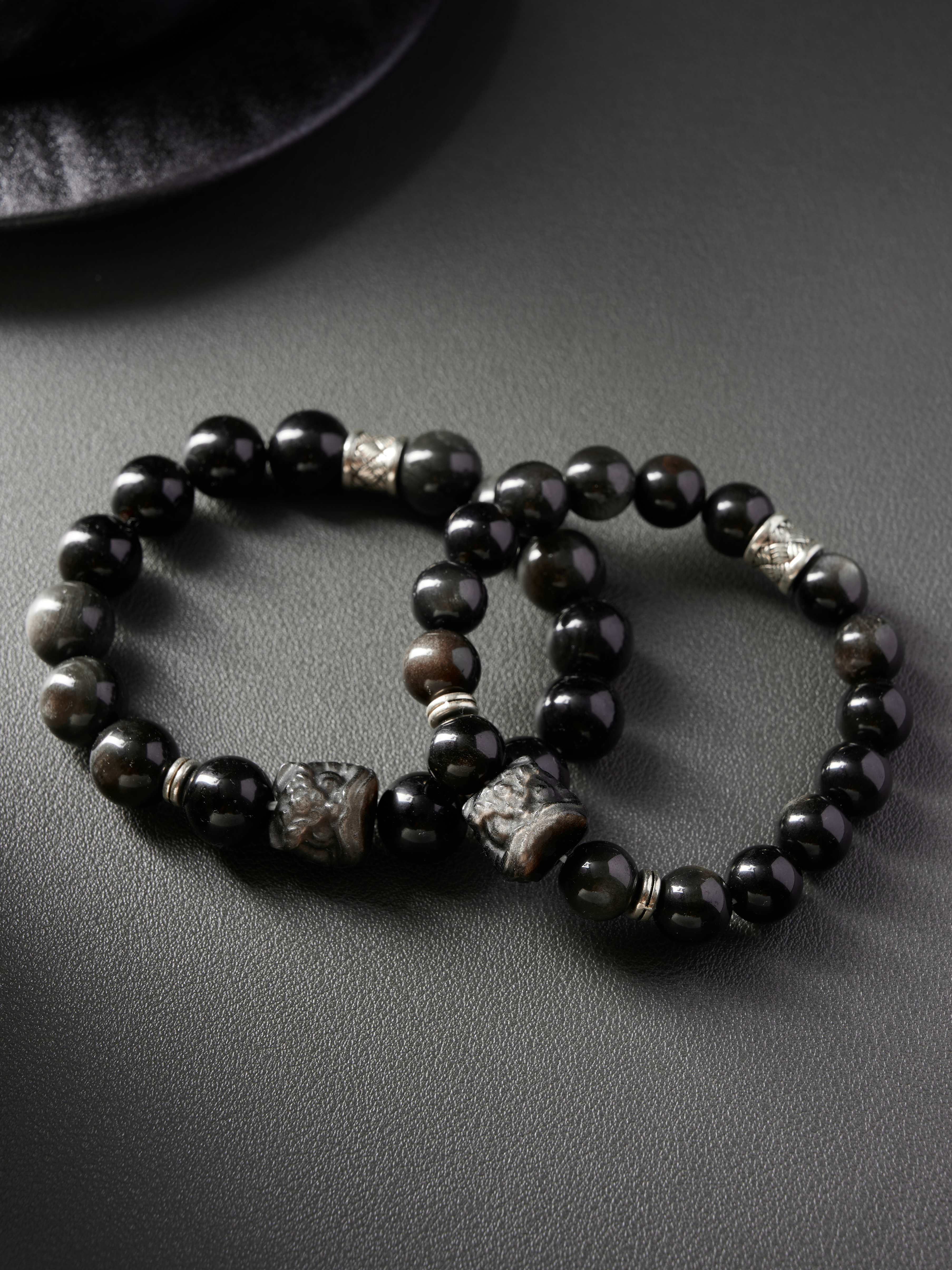 Top-down flat view highlighting deep onyx shine and subtle brown undertones in natural obsidian