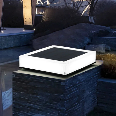 Illuminated solar-powered LED post cap light with a modern square design, featuring a frosted casing and top solar panel. Ideal for enhancing outdoor spaces like decks, pathways, and garden pillars.