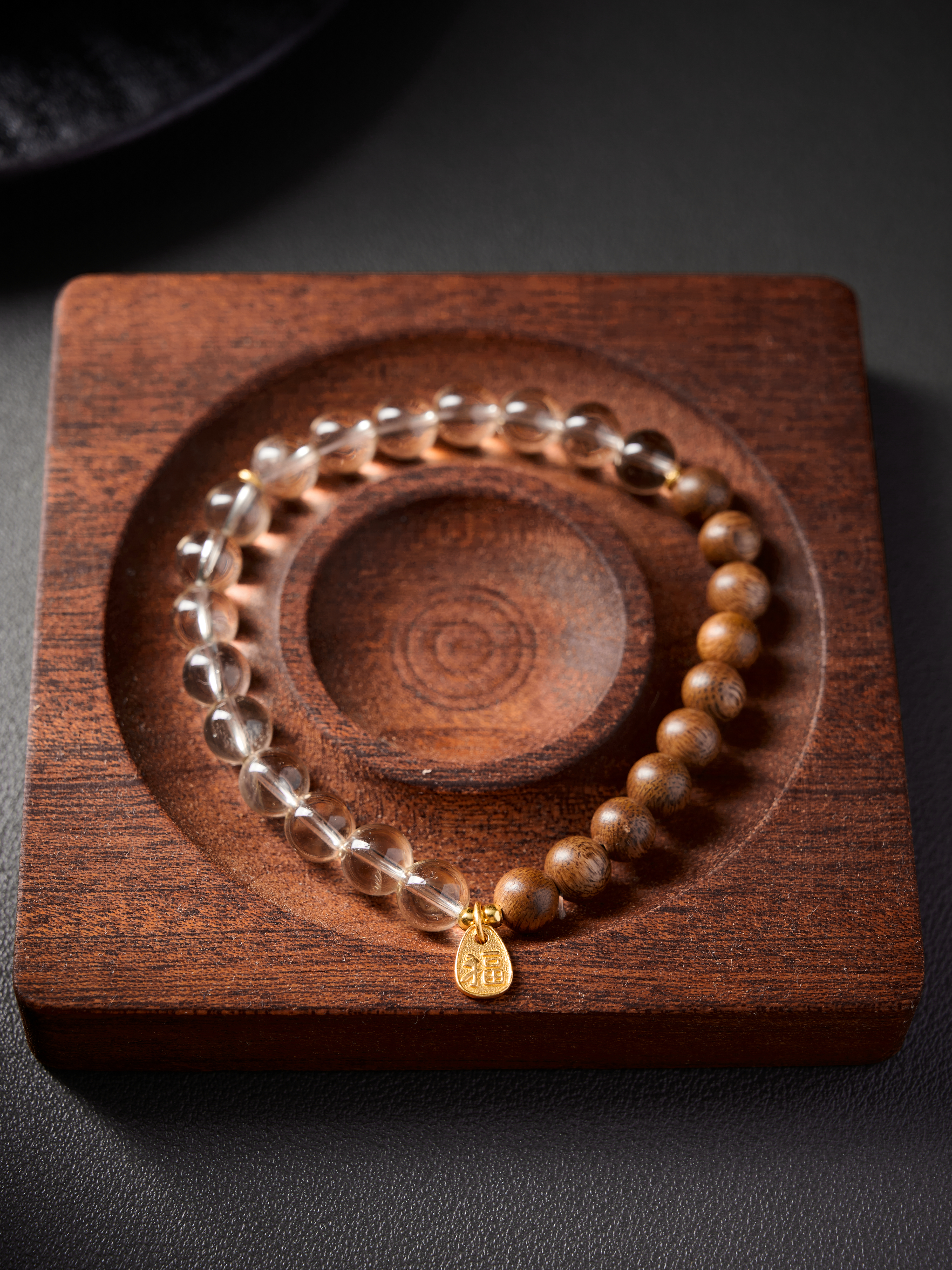 Bracelet circle composition, warm brown sandalwood contrasted with transparent crystal beads