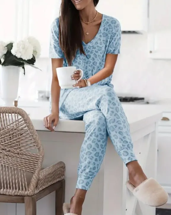 Women's V-NeckLeopard Print Loungewear Set. This relaxed-fit two-piece features a short-sleeve top and pants for effortlessly chic, casual comfort.