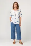 Front view of women's white and blue polka dot linen two-piece set with layered wide-leg pants