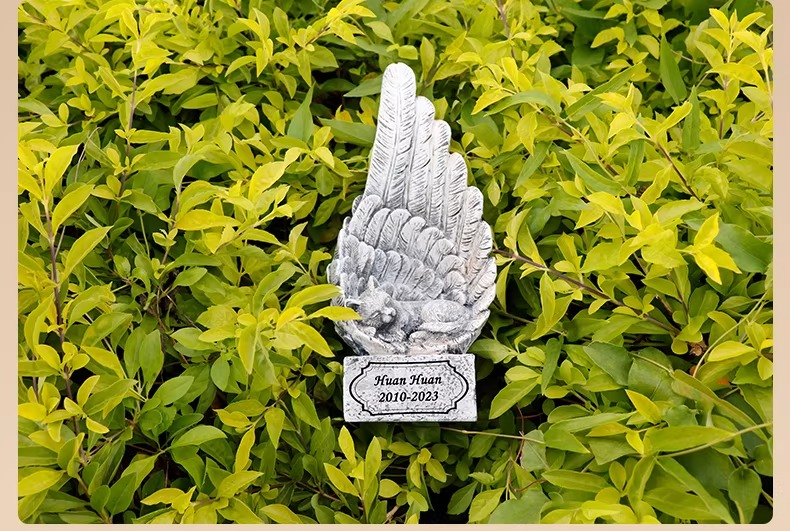 Angel wing cat memorial tombstone in garden setting