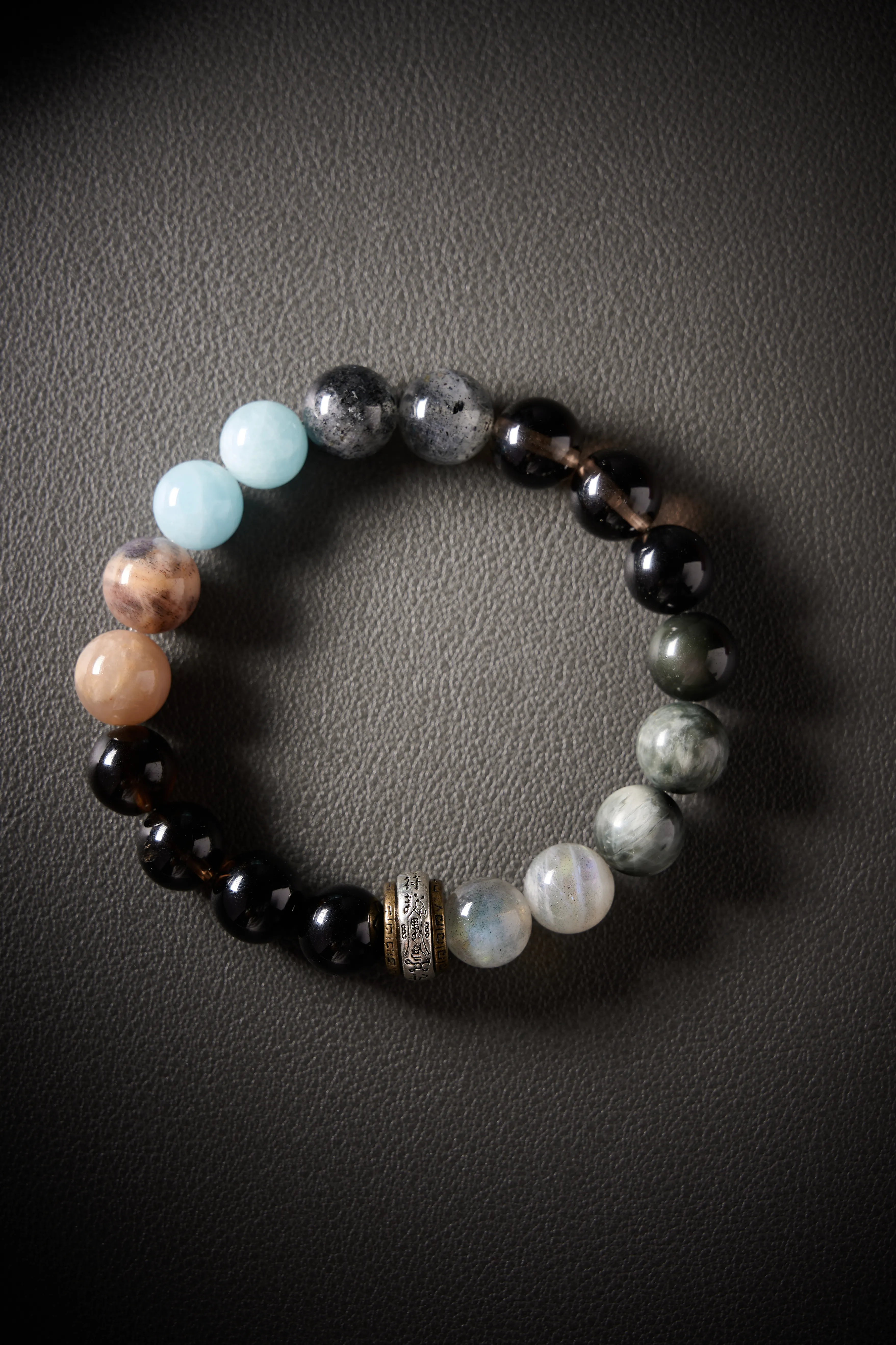 Hero image – obsidian, feldspar, moonstone and aquamarine beaded bracelet on dark background, polished round beads.