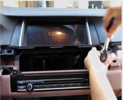 Removing the factory display and CD head-unit screws from a BMW F10 dashboard
