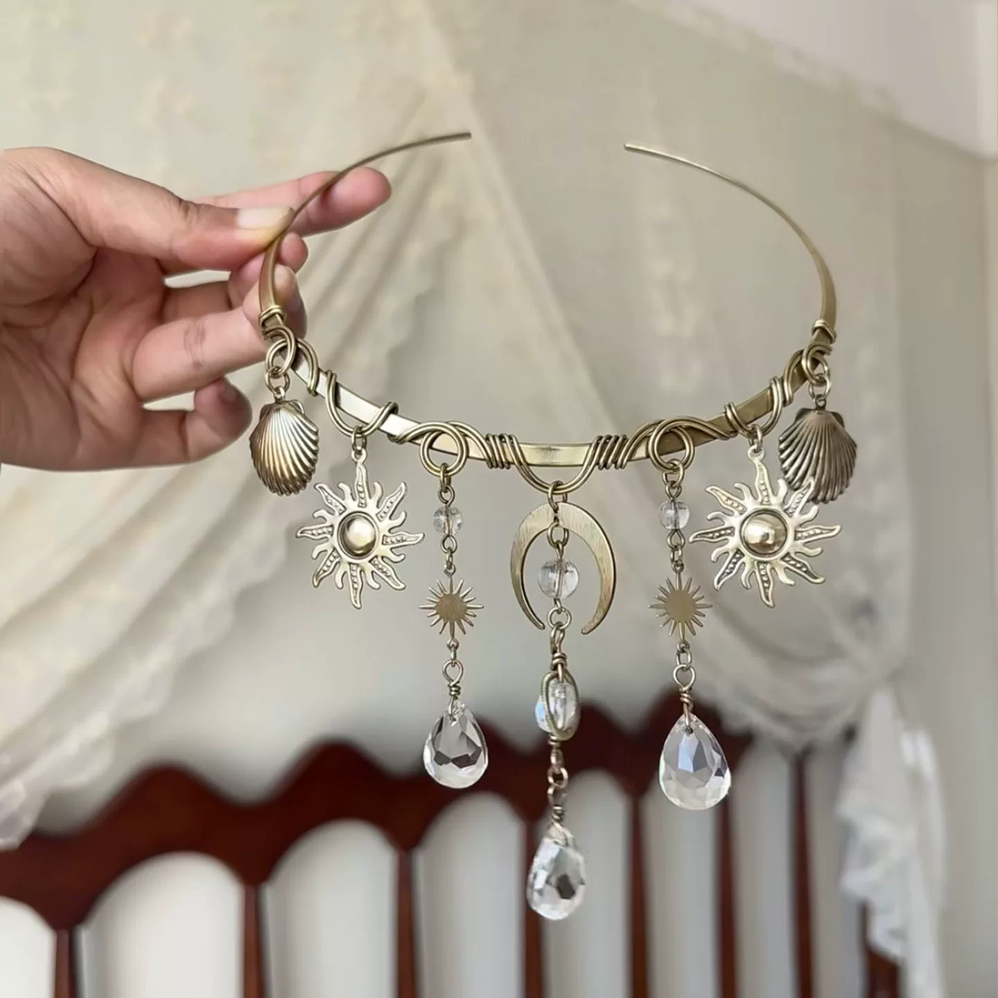 A little solar drama, in the best way. This vintage-inspired necklace is built around a hand-finished, wire-wrapped collar and a constellation of charms—sunbursts, crescent moon, and teardrop crystals that catch light like morning dew.
