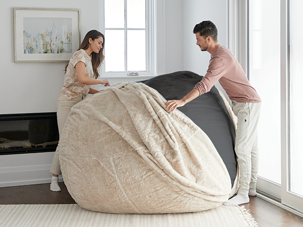 A couple is changing the cover of their Lovesac.