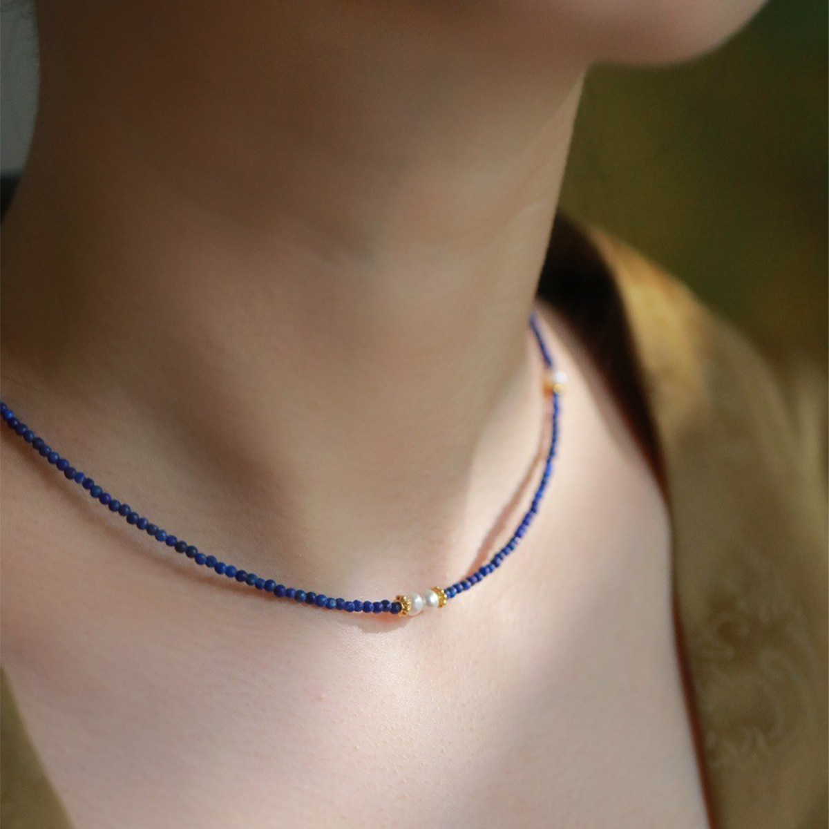 Handcrafted lapis lazuli and pearl necklace styled with a formal outfit.