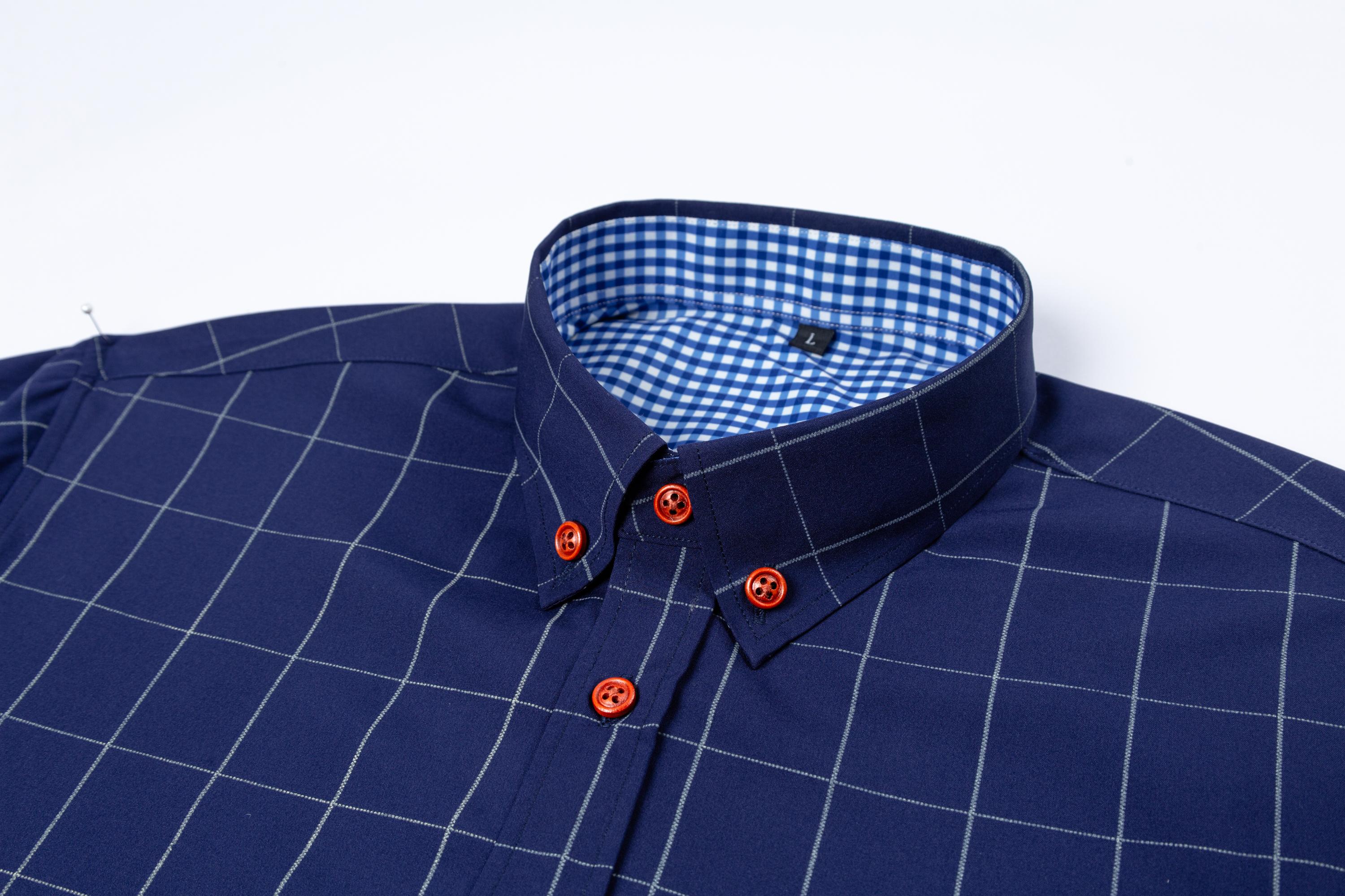 Two men’s long-sleeve shirts with a plaid color-block design, styled for business casual wear. Featuring a notched lapel collar that is sharp and well-structured, red buttons add a refined touch, and the blue-and-white plaid interior creates visual depth.