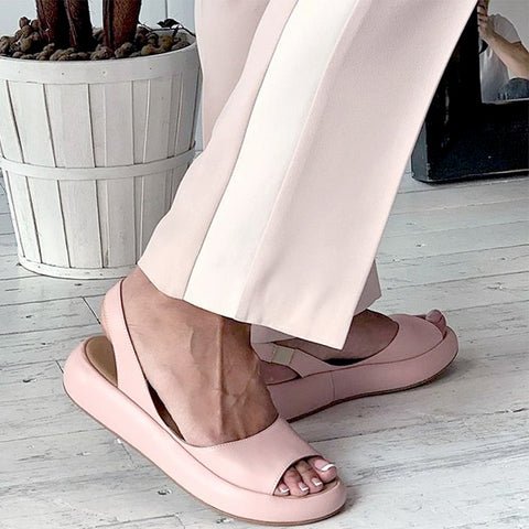 Frau trägt rosa Sommersandalen und Hose