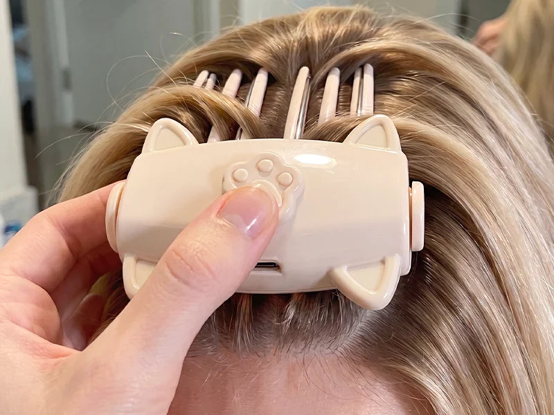 Heated root lift clip placed at the hair roots