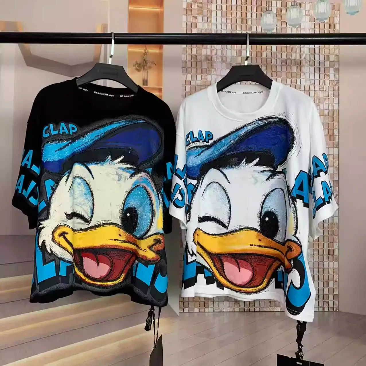 Front view of black and white oversized t-shirts with sparkling Donald Duck rhinestone print