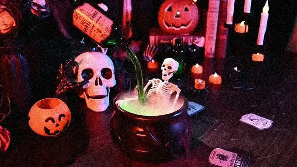 Halloween cauldron with glowing mist, skeleton and floating potion bottle