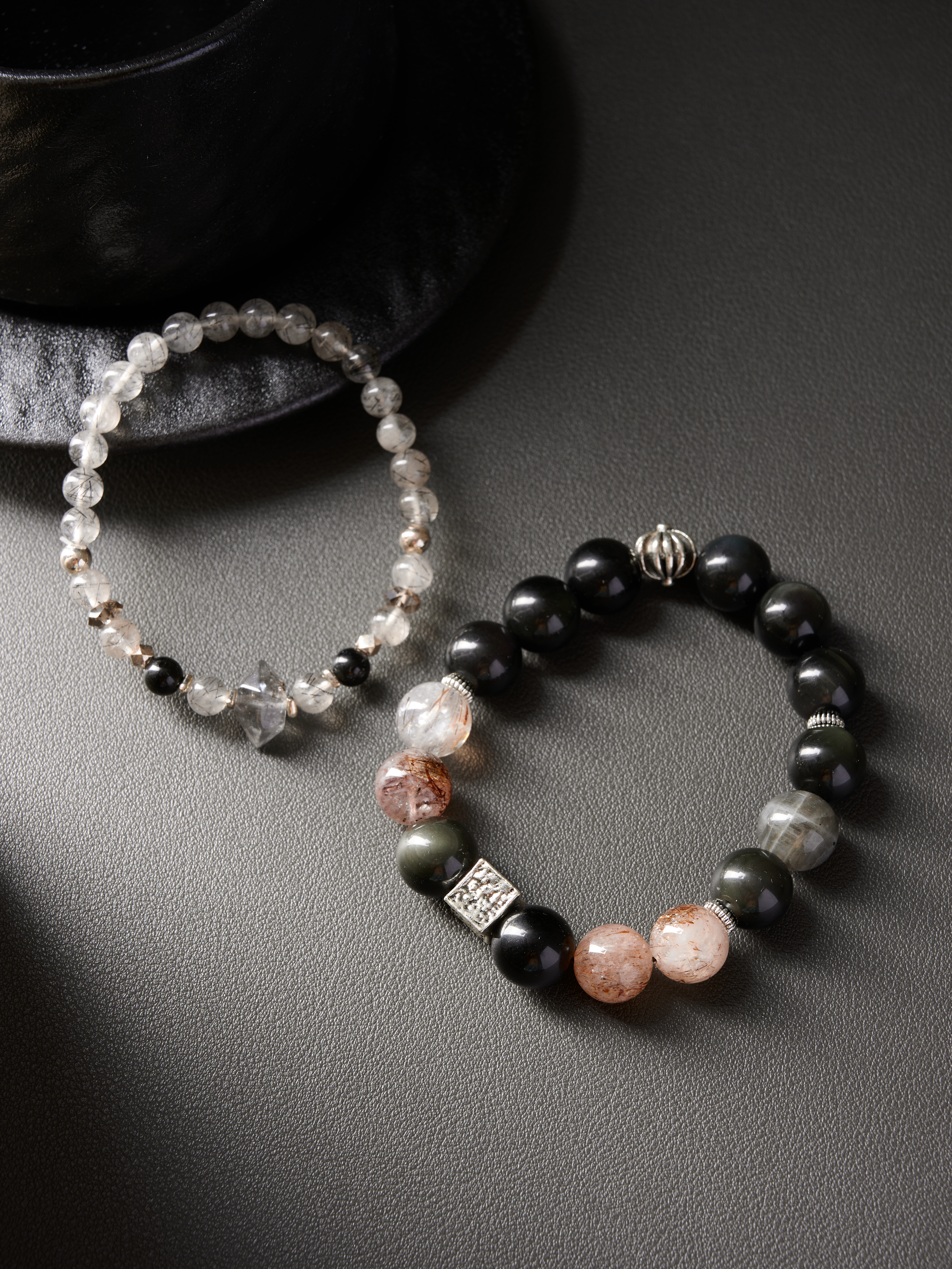 Flat lay with soft shadow, rutilated quartz focal beads contrasted with deep black obsidian