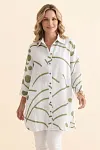 Front view of a woman wearing an olive green abstract print longline linen-blend shirt with buttons